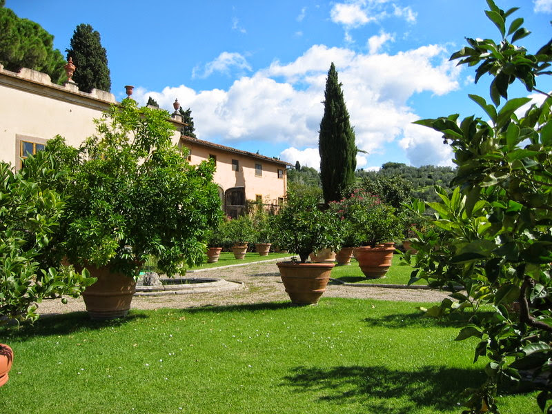 Tuscan villa garden with terracotta pots and cypress trees
